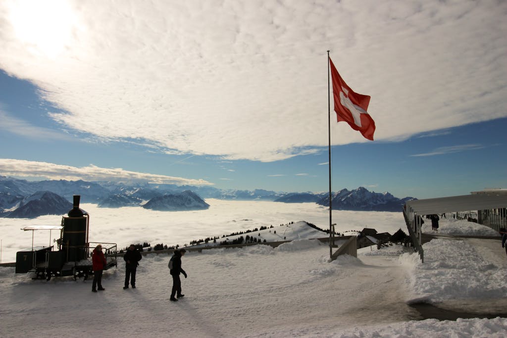 Majestic snowy view from Rigi Kulm, Switzerland, with Swiss flag and mountains.