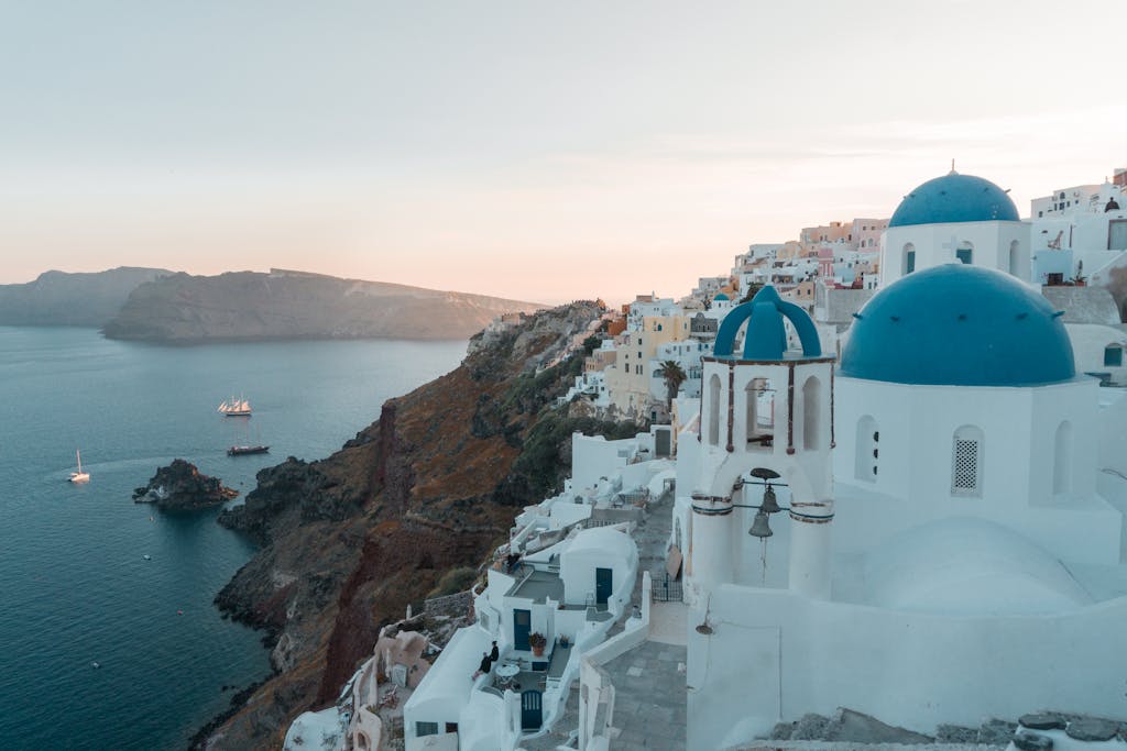 Stunning sunset view of iconic blue domes in Santorini, Greece overlooking the Aegean Sea.